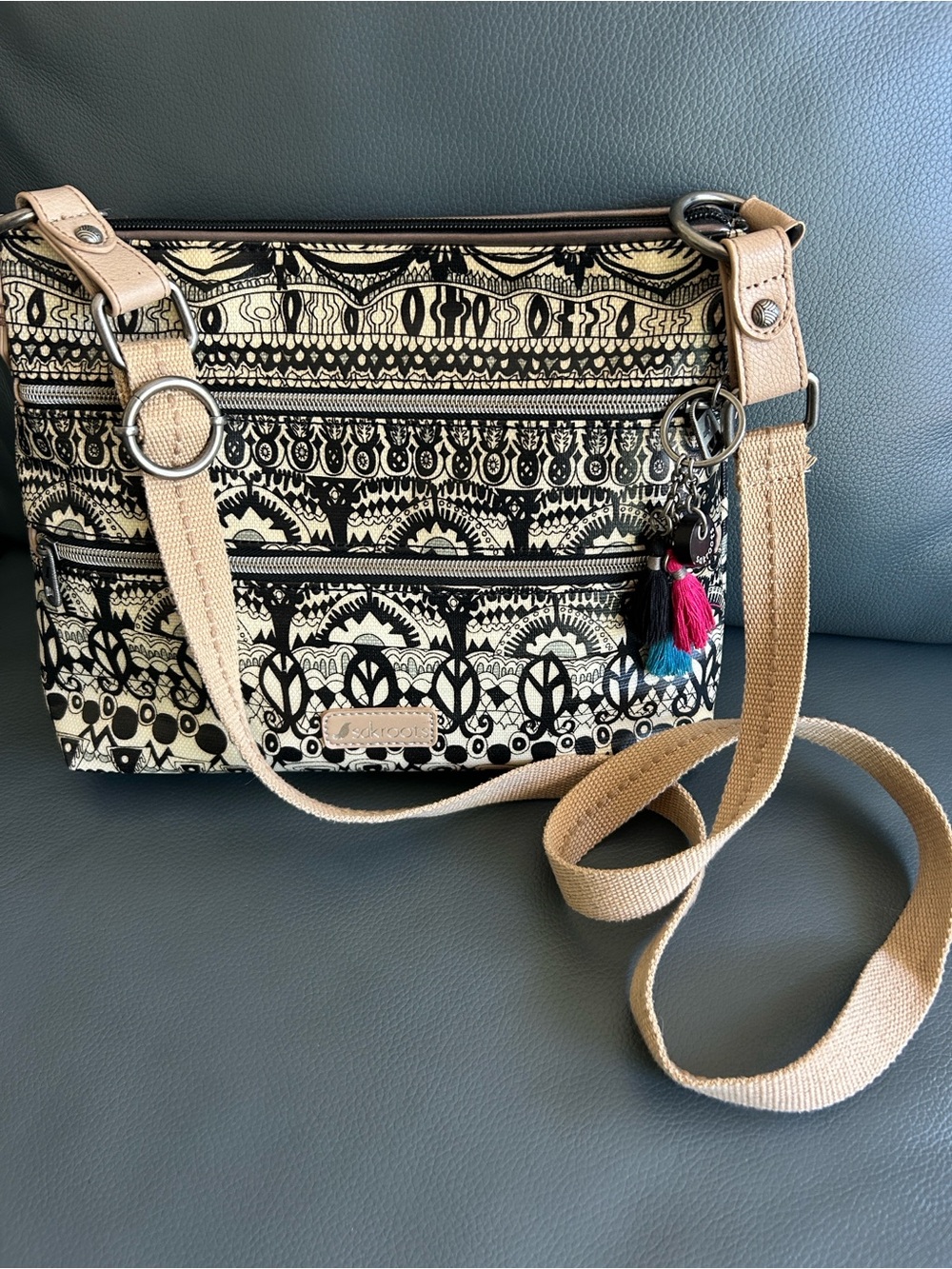 Sakroots Flat Crossbody bag features distinct black/white "Artist Circle" print